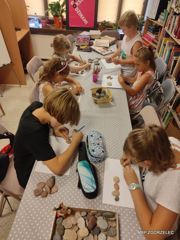 Dzieci malują na kamieniach podczas warsztatów plastycznych