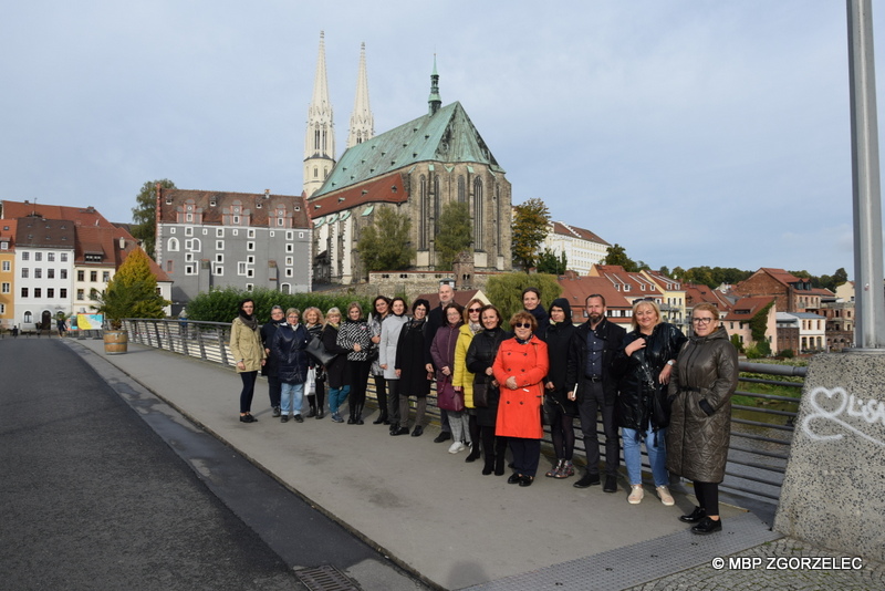 Grupowe zdjęcie uczestników spotkania wykonane na Moście Staromiejskim. W tle Kościół św. Piotra i Pawła.
