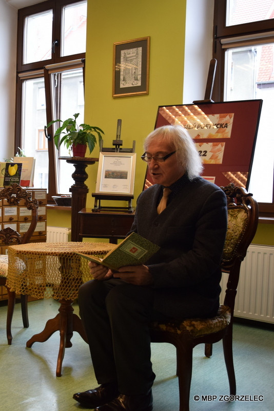 Uczestnik spotkania Dyskusyjnego Klubu Książki w Czytelni MBP czyta wiersze.