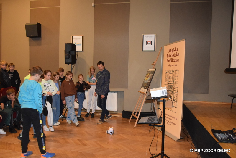 W sali kinowej Miejskiego Domu Kultury w Zgorzelcu bibliotekarz pokazuje robota edukacyjnego Photon uczniom klasy 5c ze Szkoły Podstawowej nr 3 im. Janusza Korczaka w Zgorzelcu.