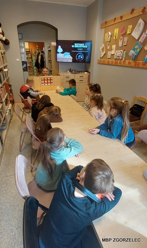 Dzieci słuchają opowiadania pt. Książka z teatrzyka Kamishibai