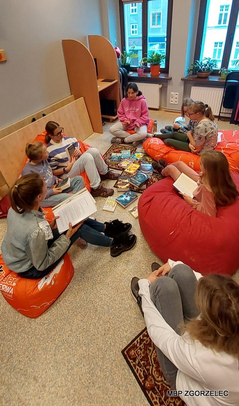 Czytelniczki w czytelni Oddziału dla Dzieci i Młodzieży czytają książki