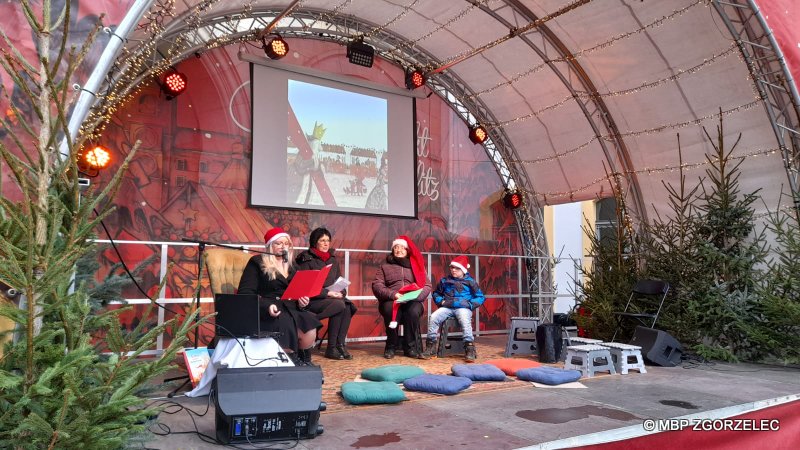 Bibliotekarka czyta świąteczne opowiadanie dla dzieci na Jarmarku Bożonarodzeniowym w Görlitz.