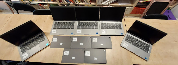Na stole leży 5 laptopów i 5 tabletów