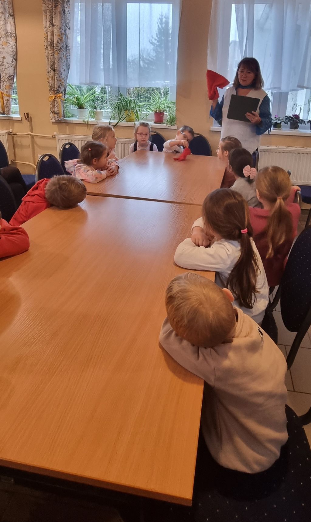 Bibliotekarka dyskutuje z dziećmi o Mikołaju.