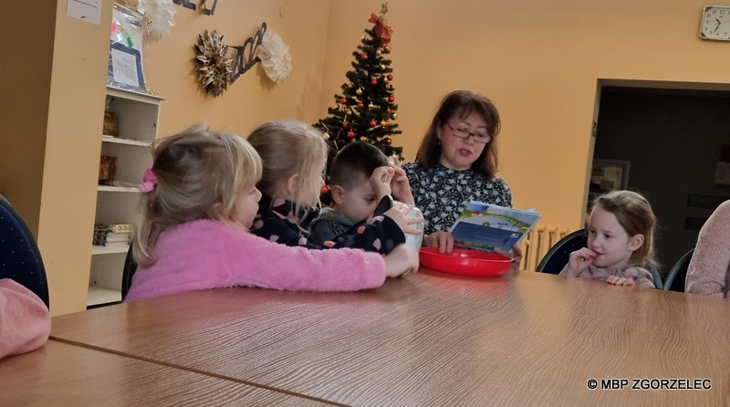 Bibliotekarka czyta dzieciom bajkę pt. "O wróbelku Elemelku" Hanny Łochockiej.