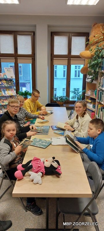 Młodzież ogląda książki w czytelni Oddziału dla Dzieci i Młodzieży
