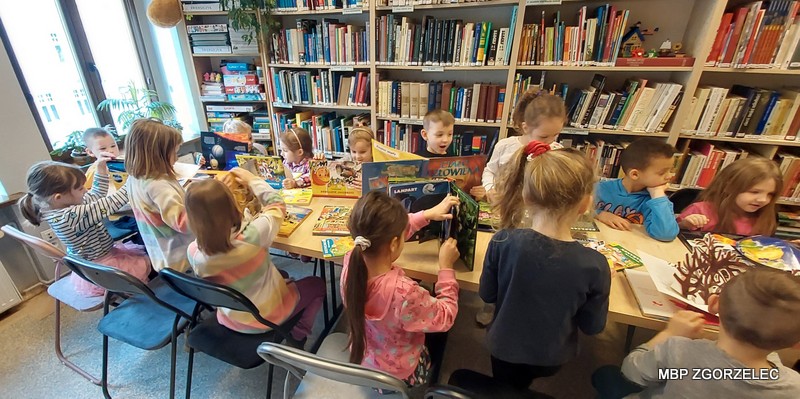 Dzieci przeglądają książki w czytelni Oddziału dla Dzieci