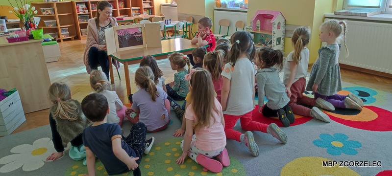 Dzieci słuchają opowiadania z teatrzyku kamishibai w Przedszkolu Kasztankowycm
