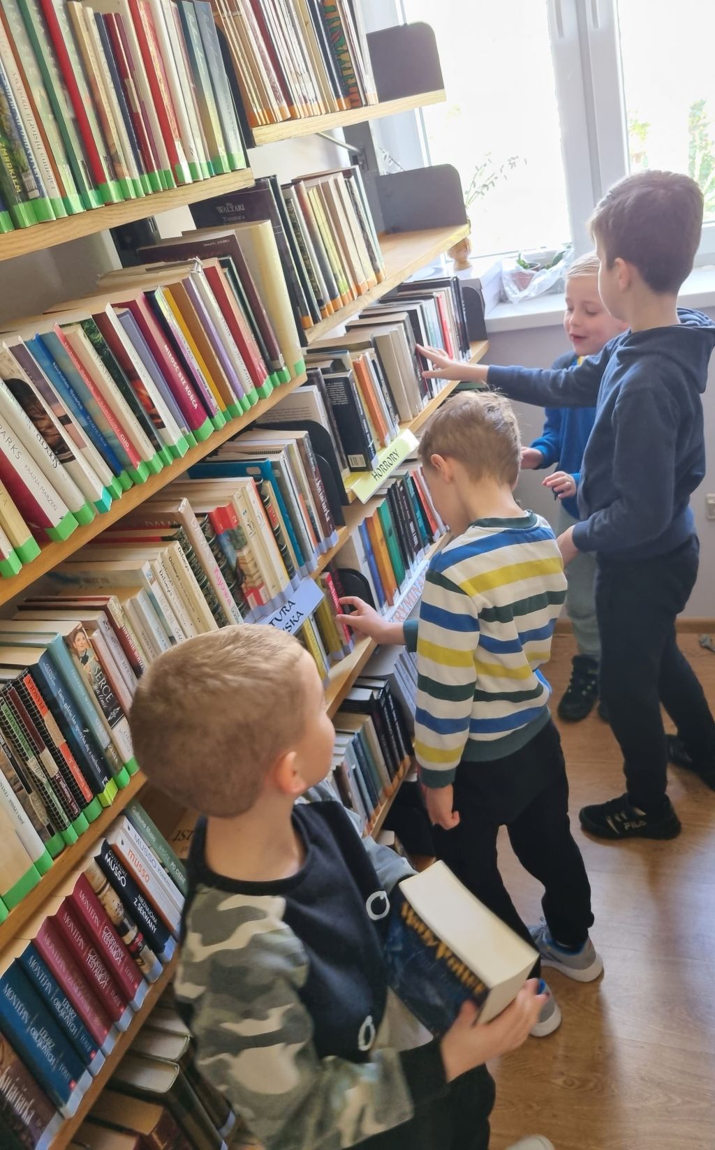 Dzieci z zainteresowaniem oglądają książki.