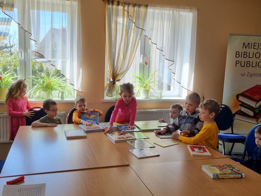 Dzieci przeglądają książki podczas spotkania w bibliotece.