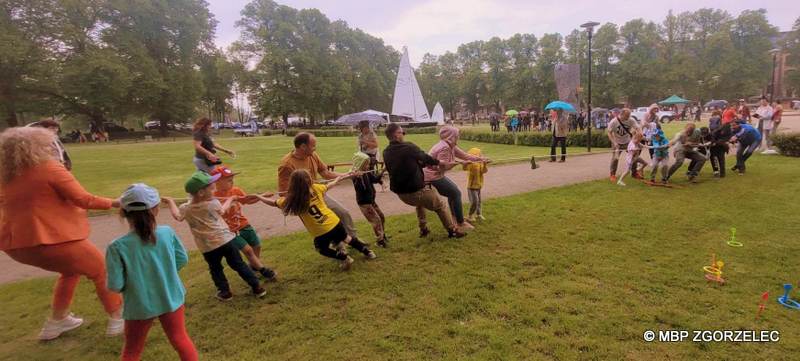 Na skwerze ks. Jerzego Popiełuszki grupa dzieci bierze udział w zabawie przeciągania liny.