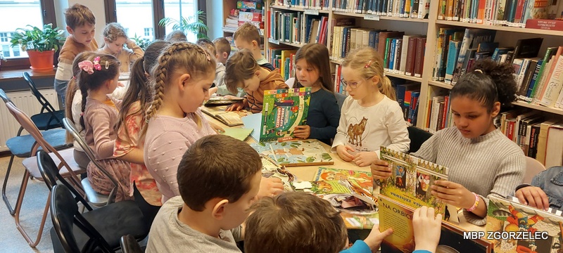 Dzieci przeglądają książki w czytelni