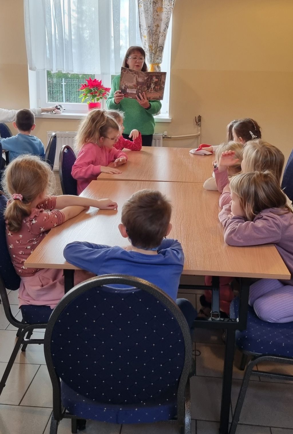 Spotkanie z przedszkolakami, bibliotekarka czyta bajkę.