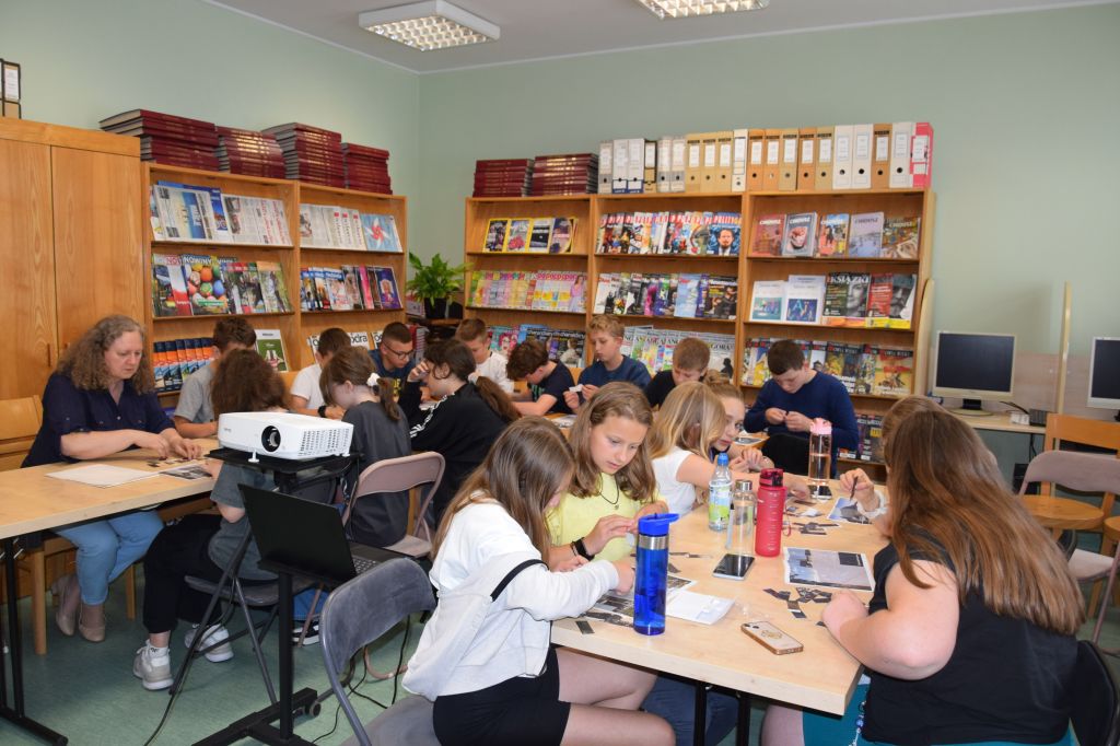 Lekcja biblioteczna o zbiorach regionalnych dla uczniów Szkoły Podstawowej nr 5 im. Marii Skłodowskiej-Curie w Zgorzelcu. Uczniowie układają puzzle.