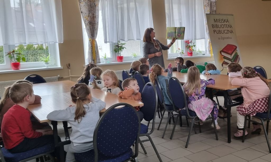 Bibliotekarka czyta dzieciom bajkę "Słoń Elmer".