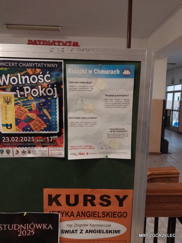 Plakat promujący kampanię "Książki w chmurach" powieszony na tablicy ogłoszeń na szkolnym korytarzu.