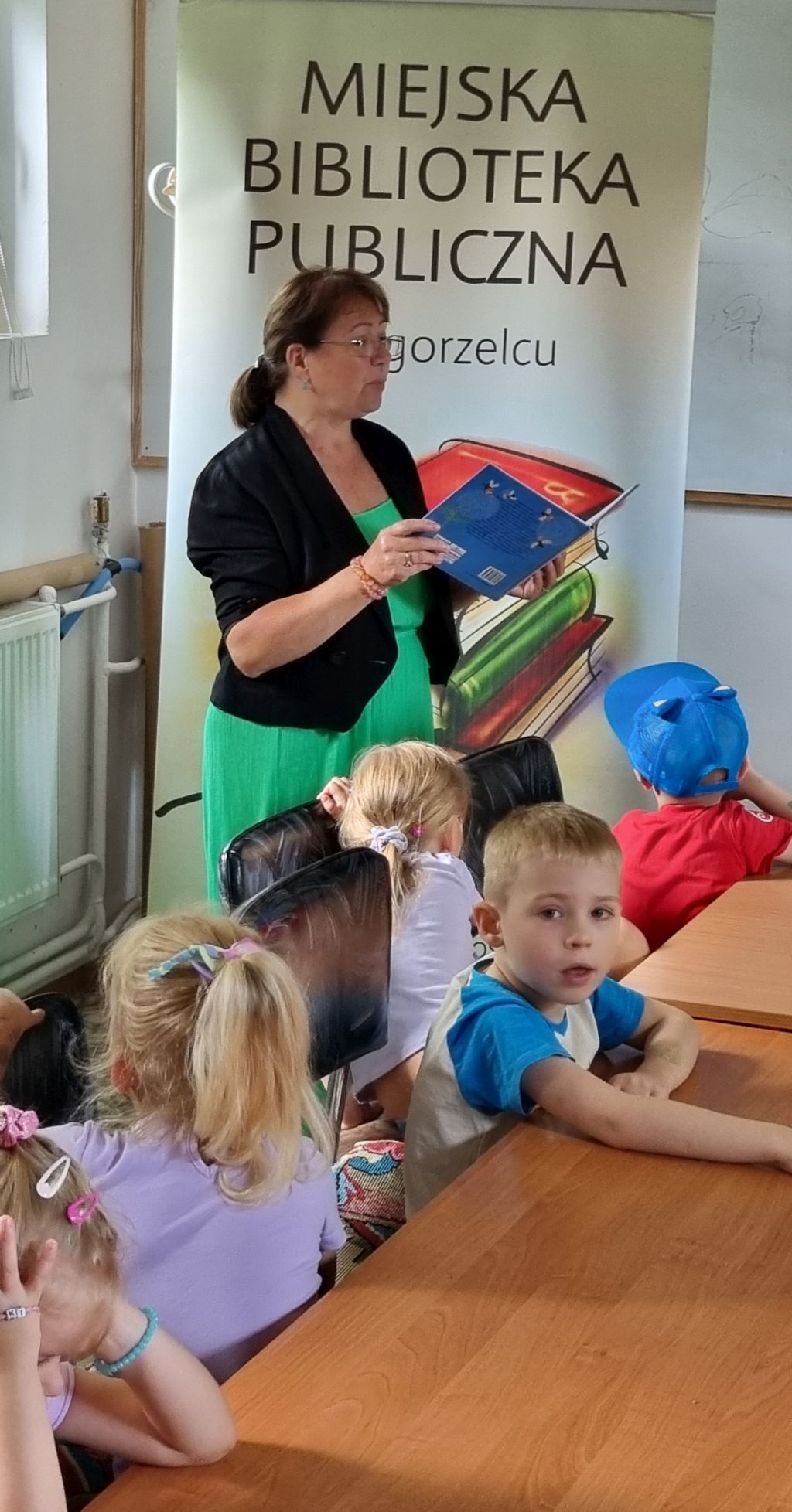 Bibliotekarka czyta bajkę dla przedszkolaków.