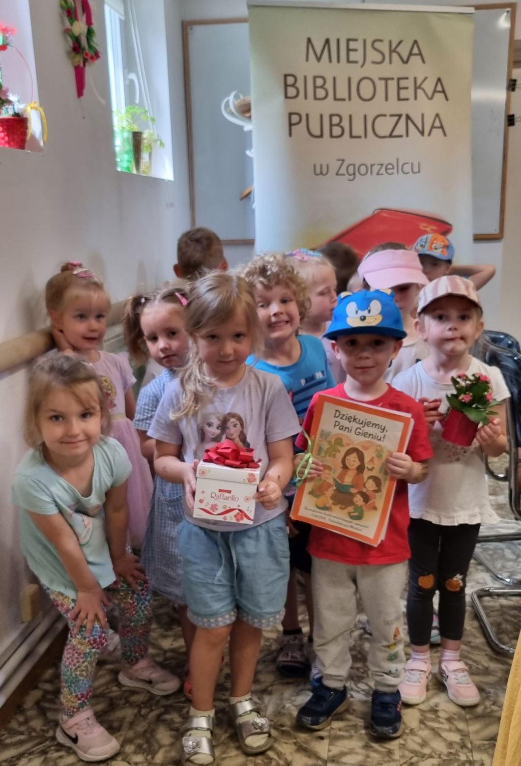Wspólne zdjęcie przedszkolaków po zajęciach w bibliotece.