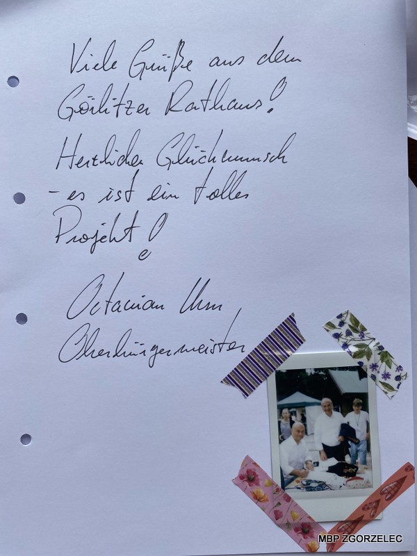 Zdjęcie kartki z wiadomością w języku niemieckim: 'Viele Grüße aus dem Görlitzer Rathaus! Herzliche Glückwunsch – es ist ein tolles Projekt! Octavian Ursu, Oberbürgermeister', zawierającą gratulacje od burmistrza Görlitz.