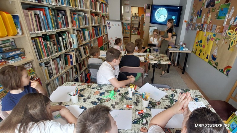 Dzieci uczestniczą w zajęciach programowania animowanej postaci Scottie Go! w bibliotece.