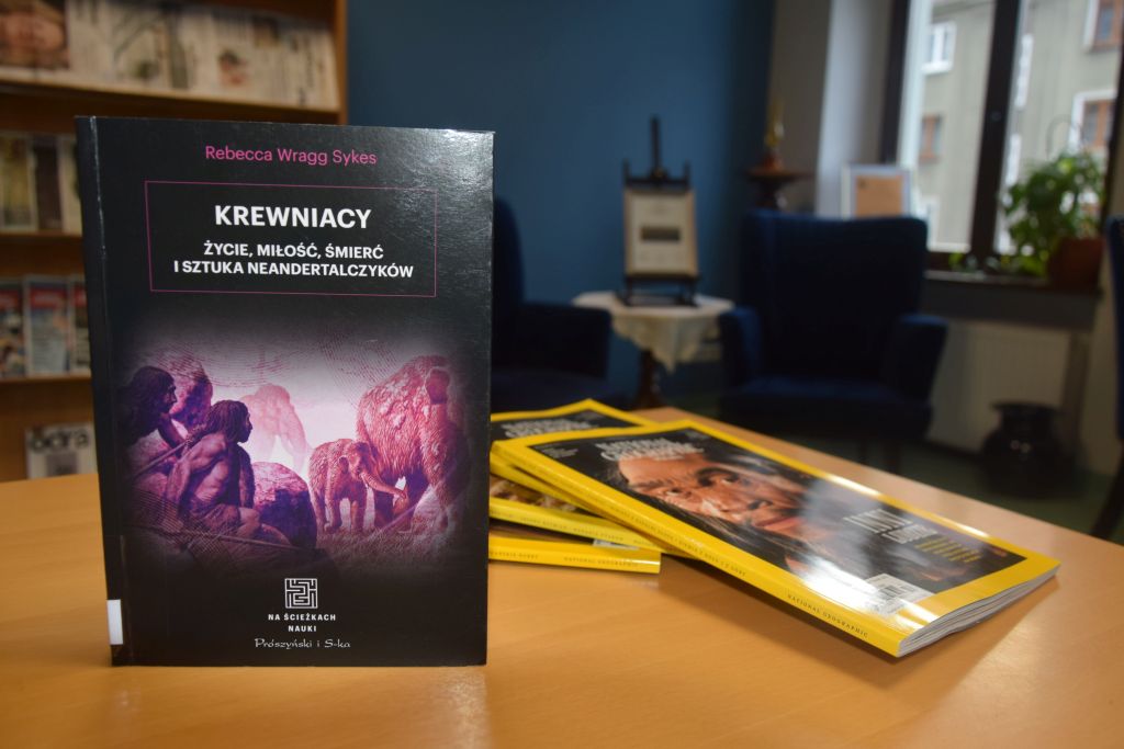 Książka „Krewniacy. Życie, miłość, śmierć i sztuka neandertalczyków” w Czytelni MBP. Zdjęcie jest odnośnikiem do wpisu o książce i październikowym wydaniu „National Geographic Polska”.