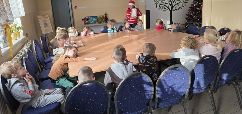 Spotkanie z&nbsp;przedszkolakami w&nbsp;bibliotece, bibliotekarka czyta bajkę.