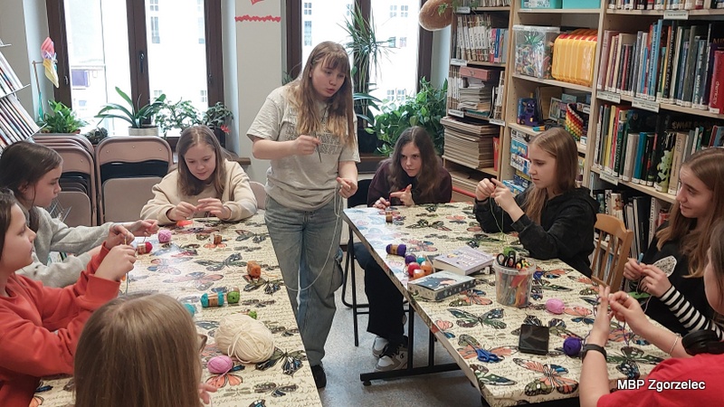 Instruktorka prezentuje technikę szydełkowania z&nbsp;włóczką podczas warsztatów rękodzieła.