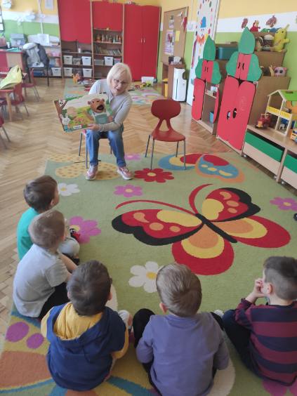Bibliotekarka pokazuje przedszkolakom ilustrację z&nbsp;książki.