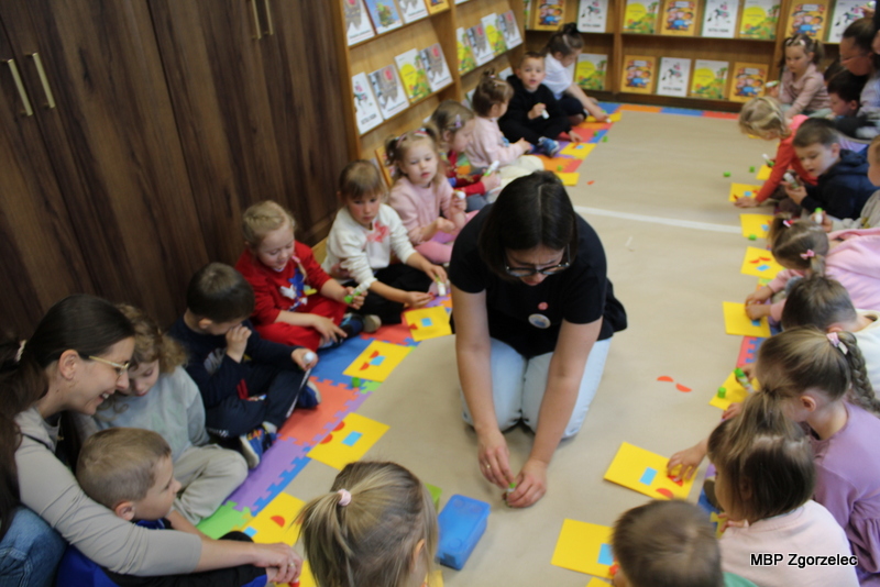 Agnieszka Błazy prowadzi warsztaty plastyczno‑czytelnicze dla najmłodszych w&nbsp;Miejskiej Bibliotece Publicznej w&nbsp;Zgorzelcu. Dzieci siedzą na kolorowych matach i&nbsp;wykonują prace inspirowane książką „Bobuś”.
