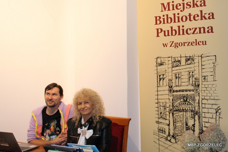 Stoisko Miejskiej Biblioteki Publicznej w&nbsp;Zgorzelcu podczas Zgorzeleckiego Konwentu Fantastycznego. Na stole znajdują się czasopisma, materiały promocyjne biblioteki oraz gry planszowe.